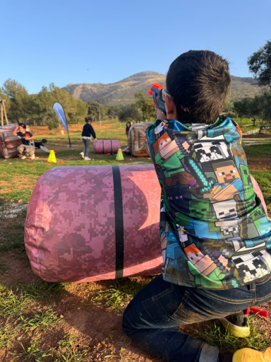 Niño jugando en una emocionante batallas Nerf, preparado para lanzar un ataque sorpresa durante una fiesta de cumpleaños.